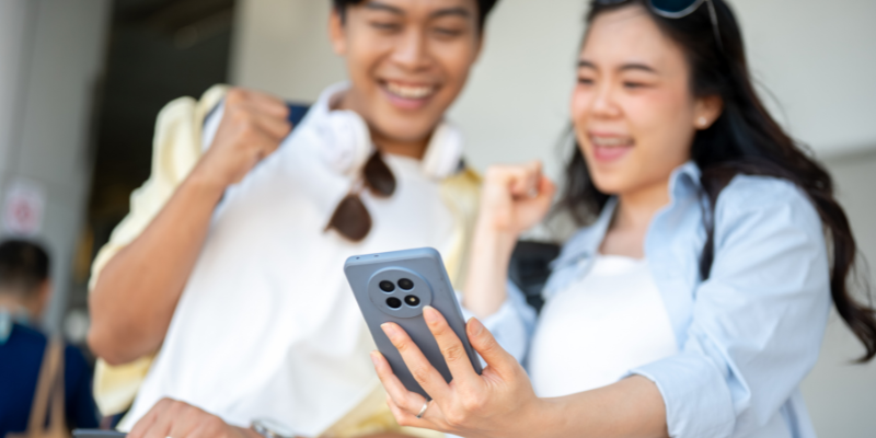 A man and a woman are happy while looking at the phone