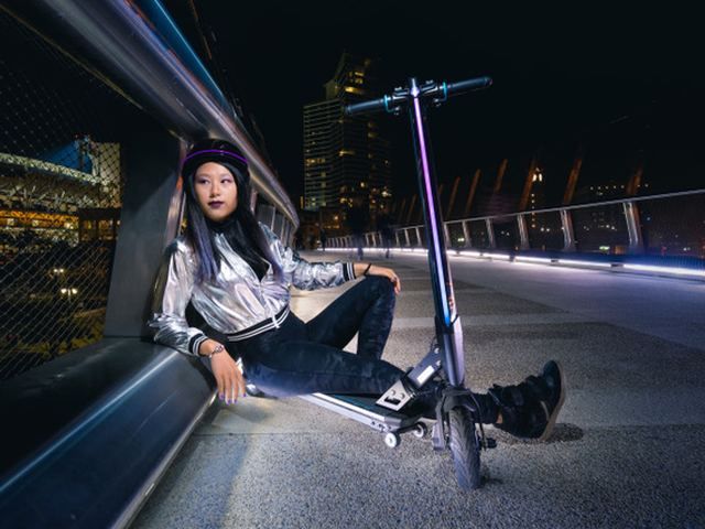Rose Song Wang at night with a Scooterboard electric scooter
