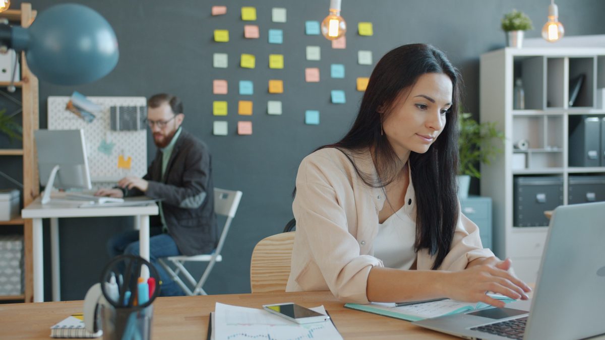 Une professionnelle travaille sur son ordinateur portable dans un bureau