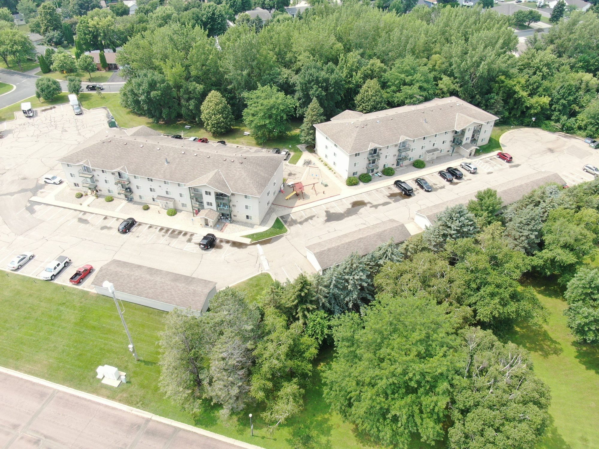 Aerial photo of two apartment buildings and garages with new shingle roofs by Repair King