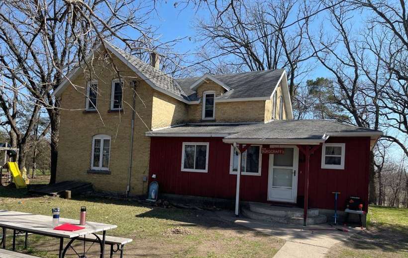 Two-story yellow brick house with a red-sided addition near Royalton, MN, photographed during a Repair King inspection