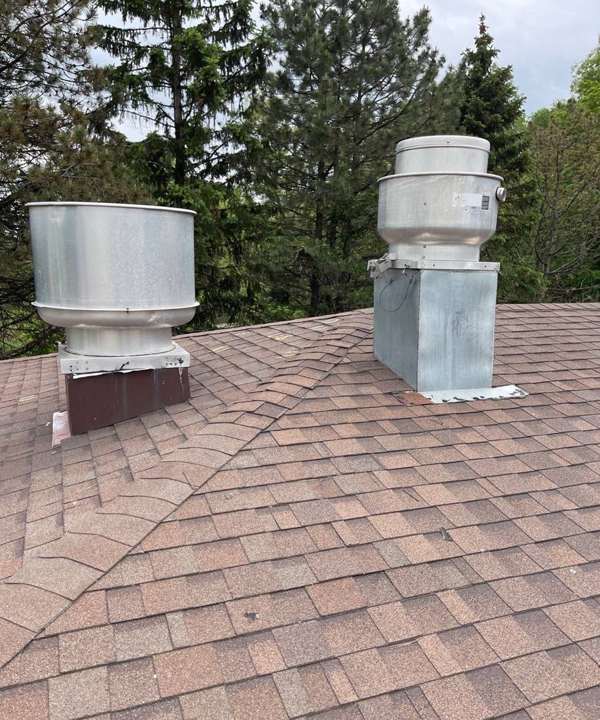 Rooftop kitchen exhaust fans on the shingle roof of Century Center strip mall on Century Avenue in Maplewood, MN, June 2022