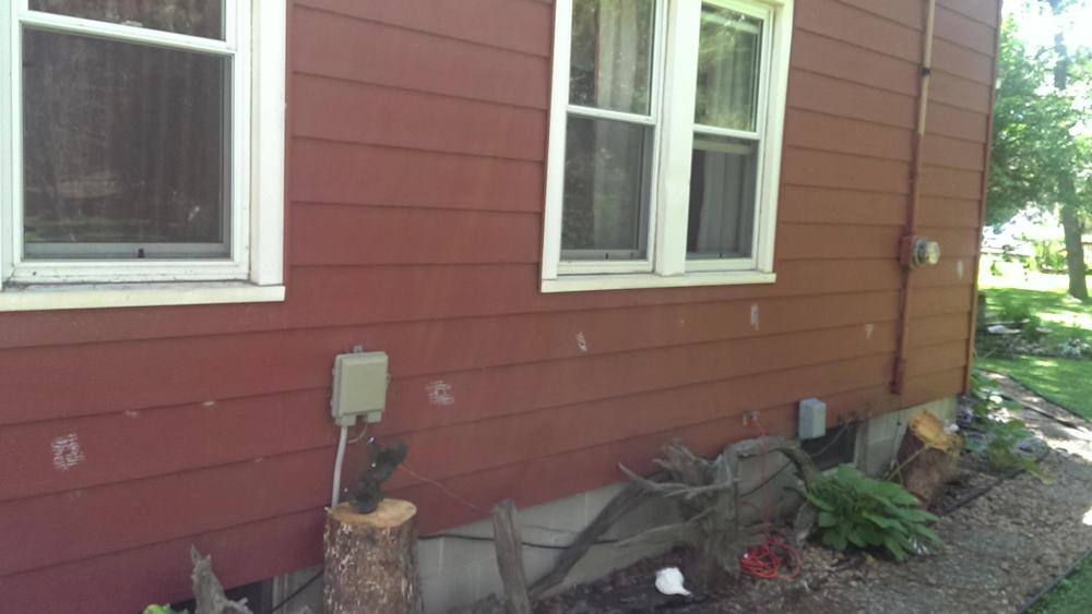 Side wall of the Hinckley home with chalk marks on the old red siding, before the exterior was replaced