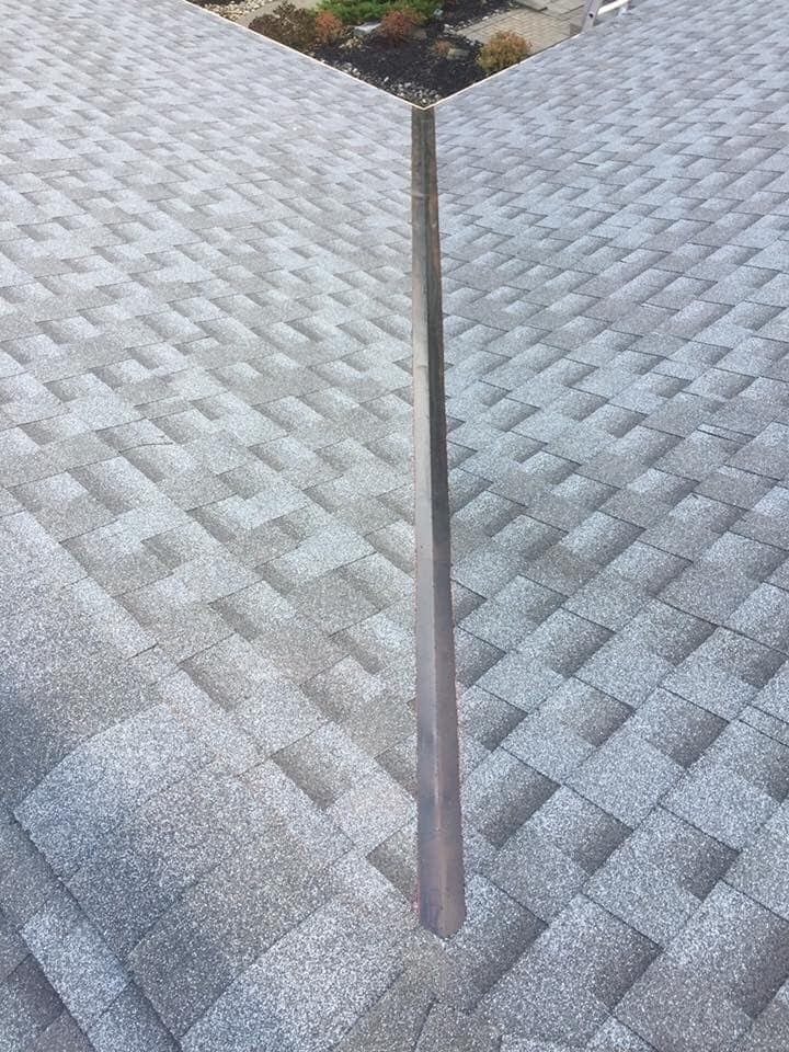 Straight, clean metal valley on a new architectural shingle roof installed by Repair King