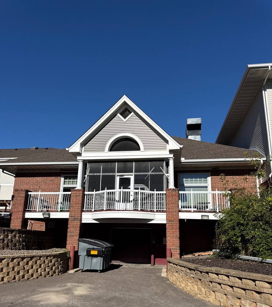 Rear entrance wing with a screened porch, brick base and shingled roof at Oak Meadows Senior Living in Oakdale, MN, September 2025