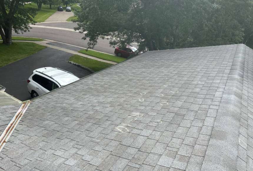 Chalk-circled hail hits marked on a gray shingle roof slope in Apple Valley's Heritage Hills, August 2025