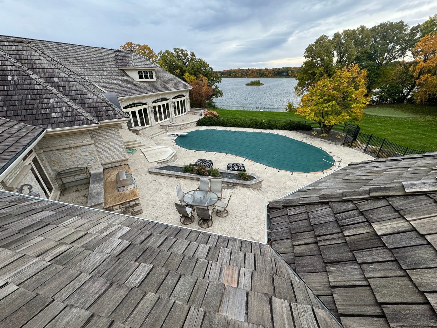 Cedar shake roof over the pool terrace of a Lake Minnetonka estate, looking toward the lake, October 2023
