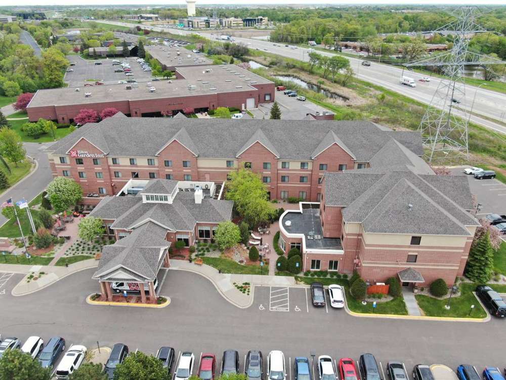 Drone view of the Hilton Garden Inn in Maple Grove, MN, with its shingle roofs and parking lot, during Repair King's May 2019 inspection