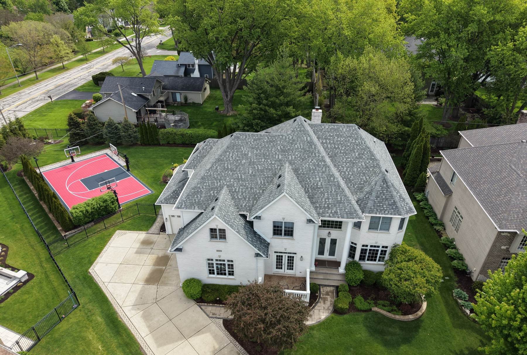 Aerial view of a Naperville home's roof, backyard basketball court and neighborhood, photographed by Repair King in May 2026