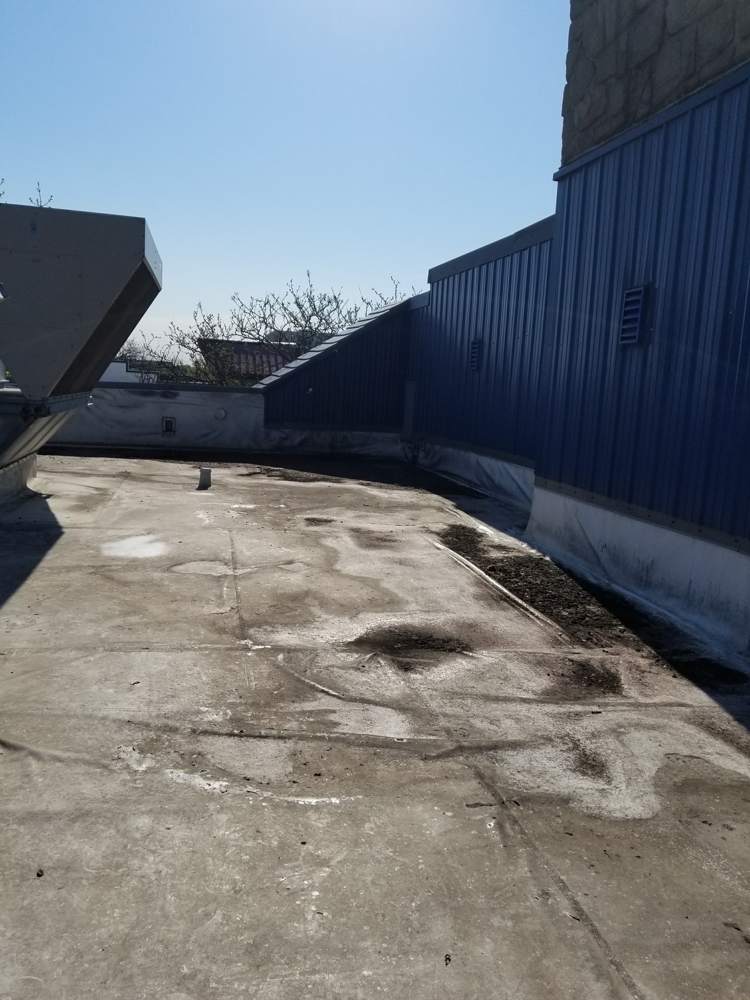 Flat roof along a metal-clad wall on the Good Earth building in Roseville
