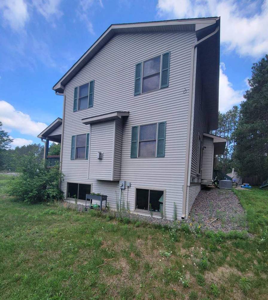 Three-story home near Big Lake photographed from the rear during an inspection, July 2022