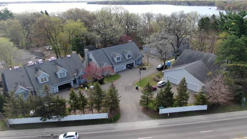 Townhome buildings with shingle bundles staged on the ridges during a Repair King re-roof in White Bear Lake