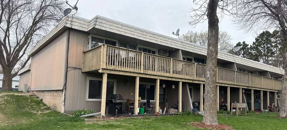 Multi-unit apartment building on Western Ave N in Faribault, photographed during a roof project, April 2026