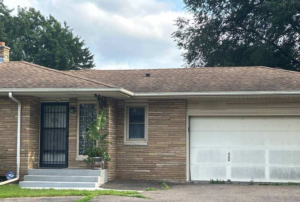 Stone-front Roseville rambler on Cleveland Avenue North during a roof inspection, August 2025