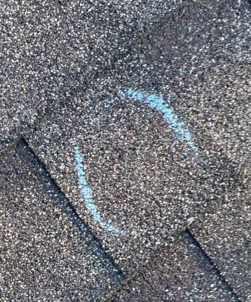 Chalk-circled hit on an architectural shingle during a Burnsville roof inspection, October 2025