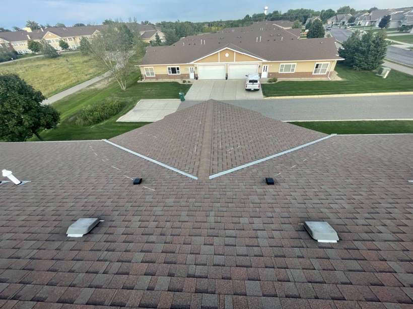 Shingle roof of a Pinecone Villas townhome in Sartell, MN, with neighboring townhomes behind it, during a September 2021 Repair King inspection