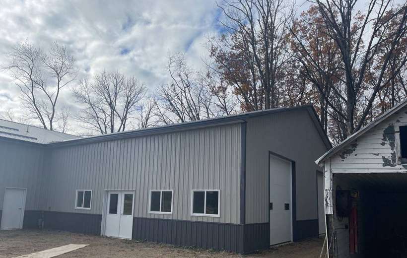 Gray steel-sided shop building with an overhead door near Royalton, MN, photographed during a Repair King roof inspection