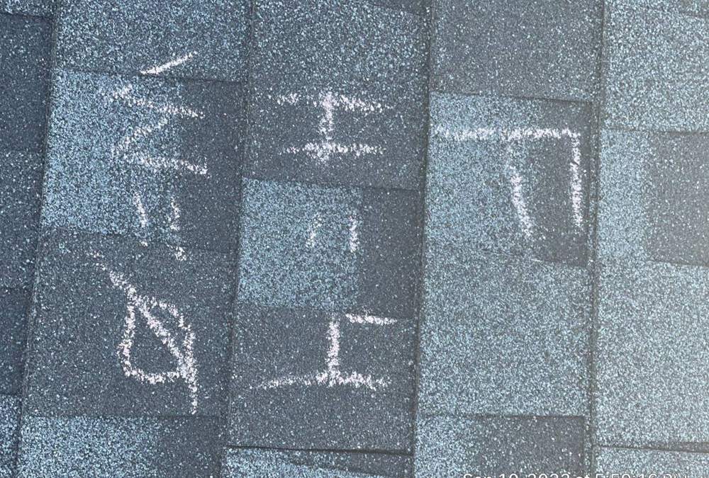 Hail hit locations chalk-marked and labeled on the Coratel Inn's shingle roof in Maple Grove, September 2022