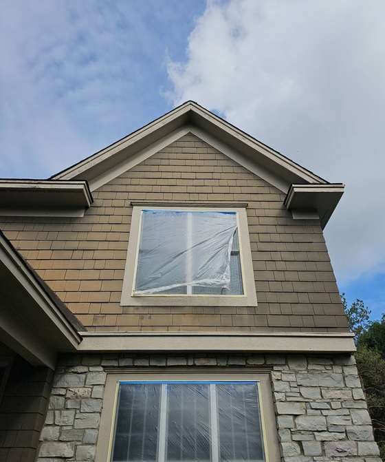 Gable of a two-story Woodbury home with shake-style siding and stone accents during a September 2025 hail inspection