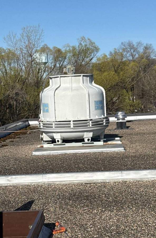 Cooling tower on the gravel-ballasted flat roof at Safe Reflections on Greeley Street South in Stillwater, MN, April 2026
