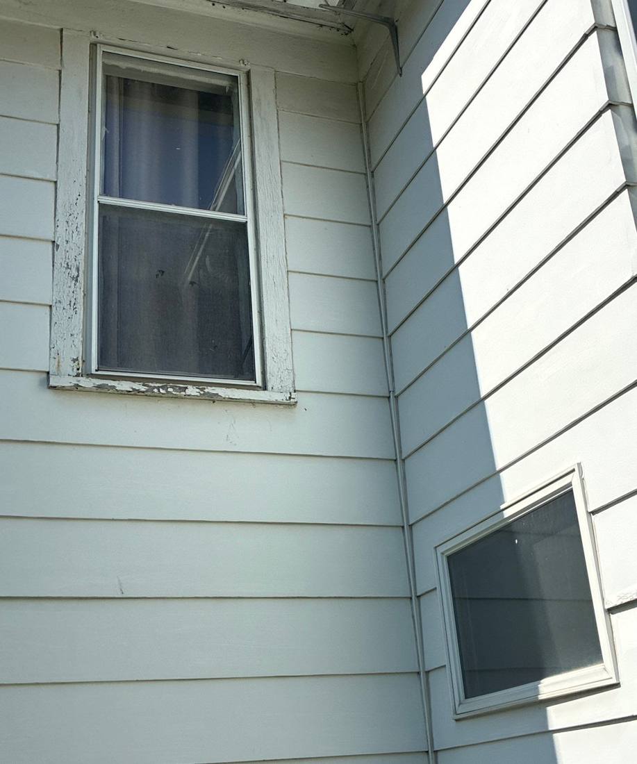 Lap siding, window trim and a basement window on an older Red Wing house, April 2026