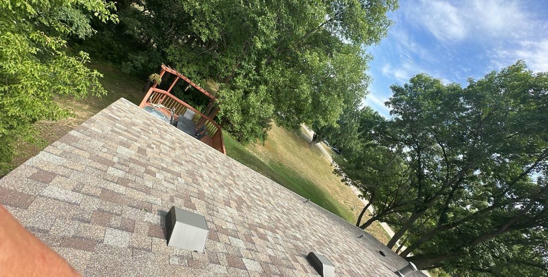 View down a Prior Lake roofline toward a backyard deck, July 2023