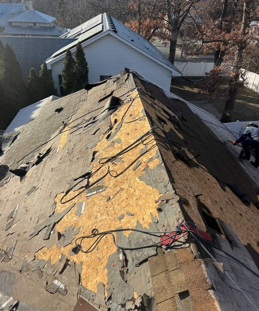 Wide view of exposed decking and old shingle debris during a Fridley roof replacement, December 2023
