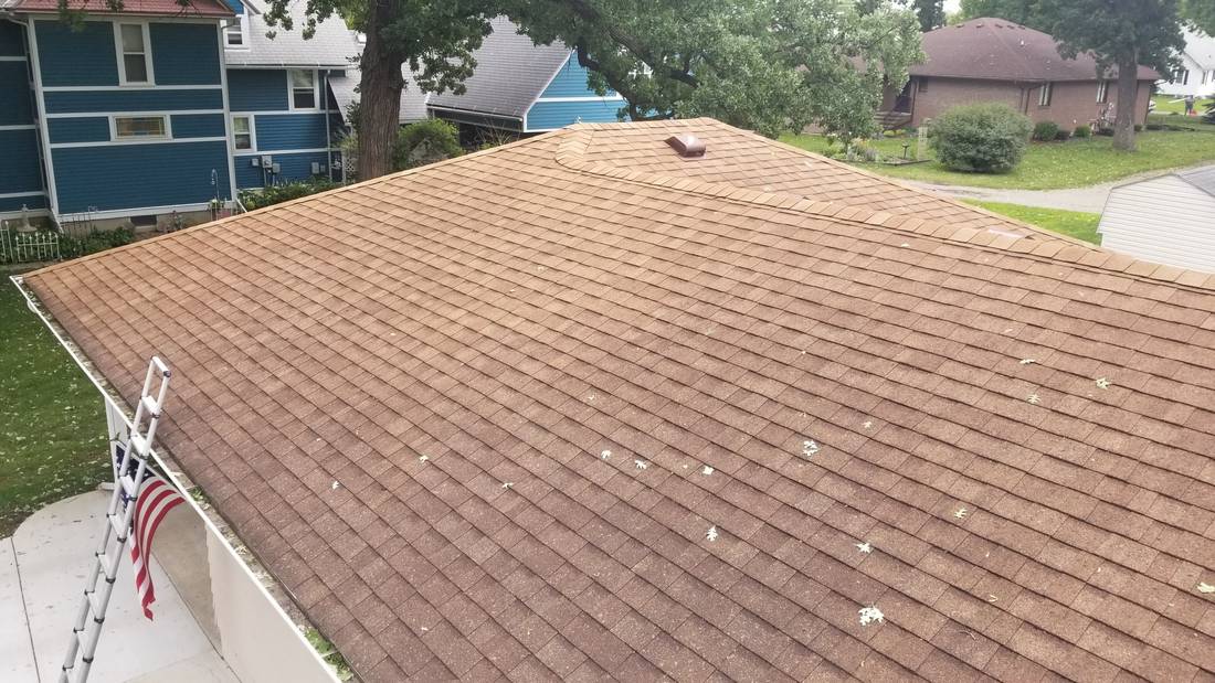 Hip roof with tan asphalt shingles and box vents on a Blue Earth, MN home, inspected by Repair King on July 25, 2018