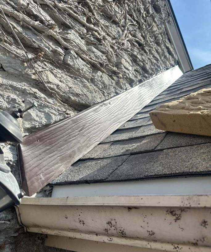 New shingles and wall flashing along the stone gable of the Richfield home, April 2025