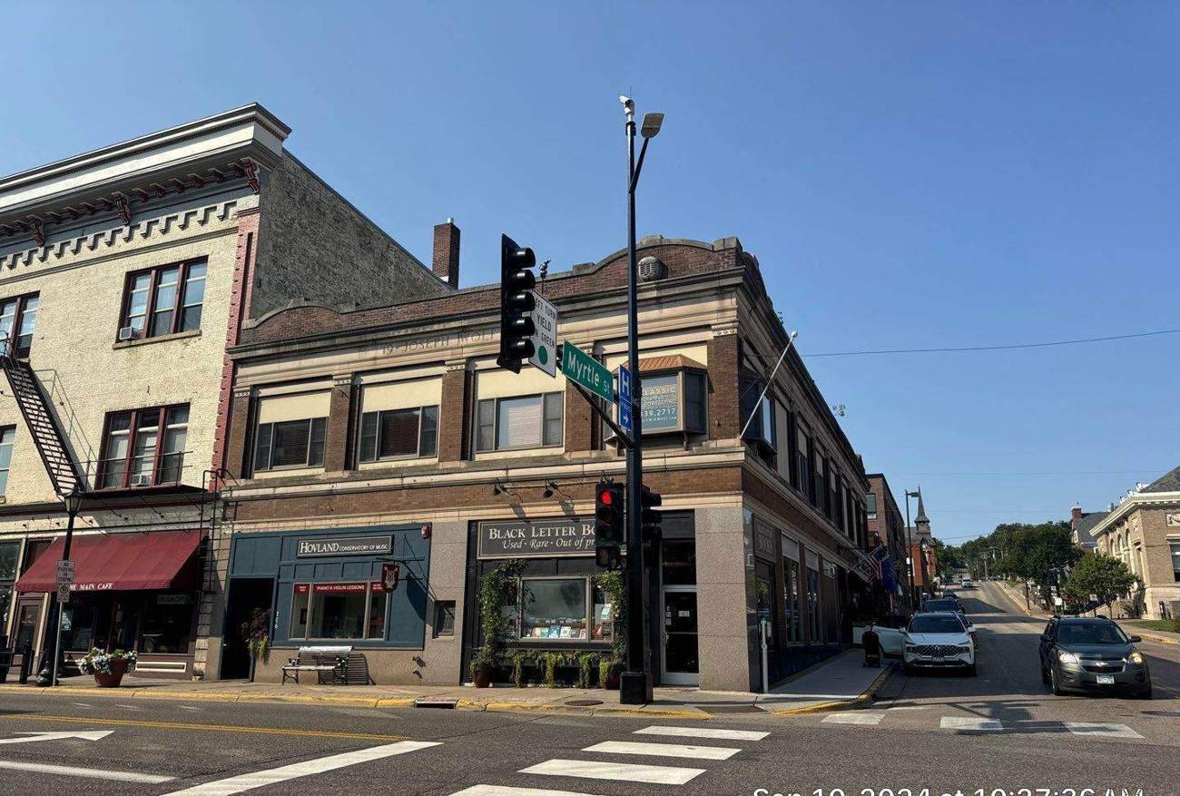 Historic two-story commercial building at the corner of Main and Myrtle streets in downtown Stillwater, MN, photographed during a Repair King roof project, September 2024