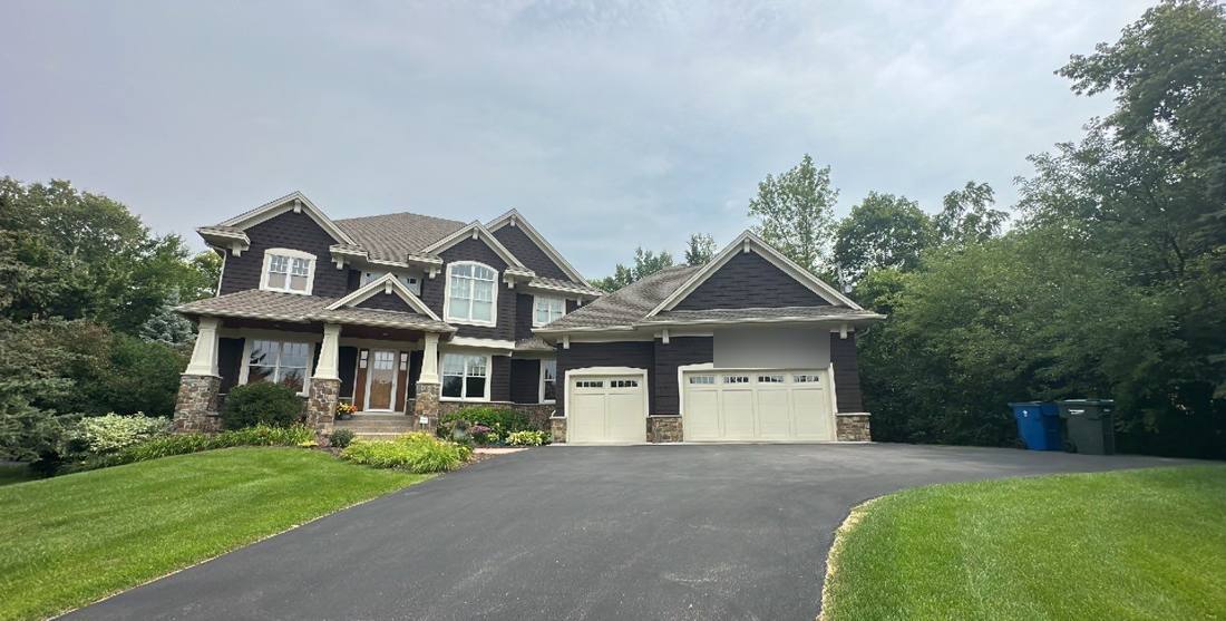 Two-story home in Hopkins with an asphalt shingle roof, photographed during a roof project, August 2023