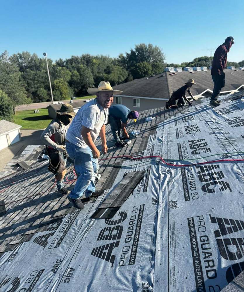 Repair King crew rolling out synthetic underlayment on the Ridgedale Square Apartments roof in Hutchinson, MN, August 2024