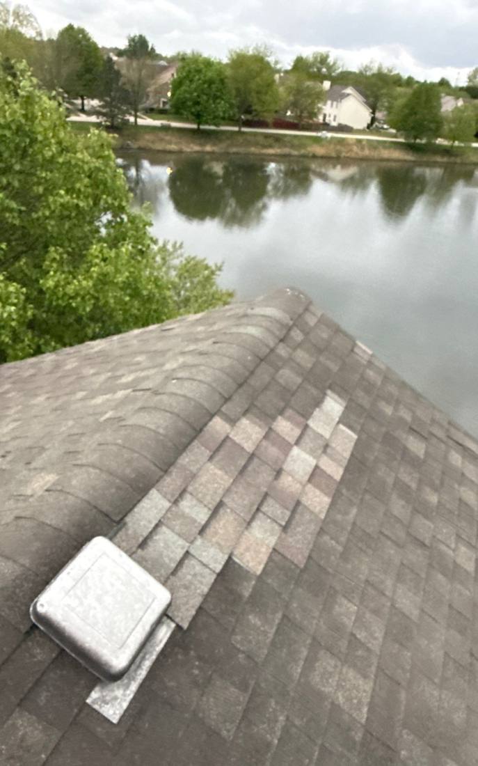 View across a Plainfield roof toward a neighborhood pond, April 2026