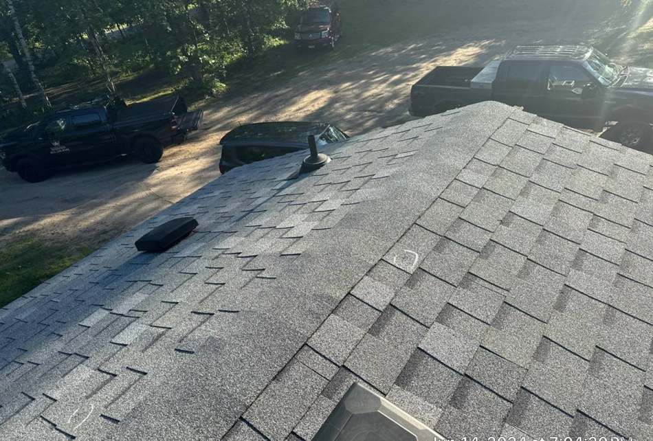 Repair King crew shadow on a Crosslake roof during a shingle inspection, June 2024
