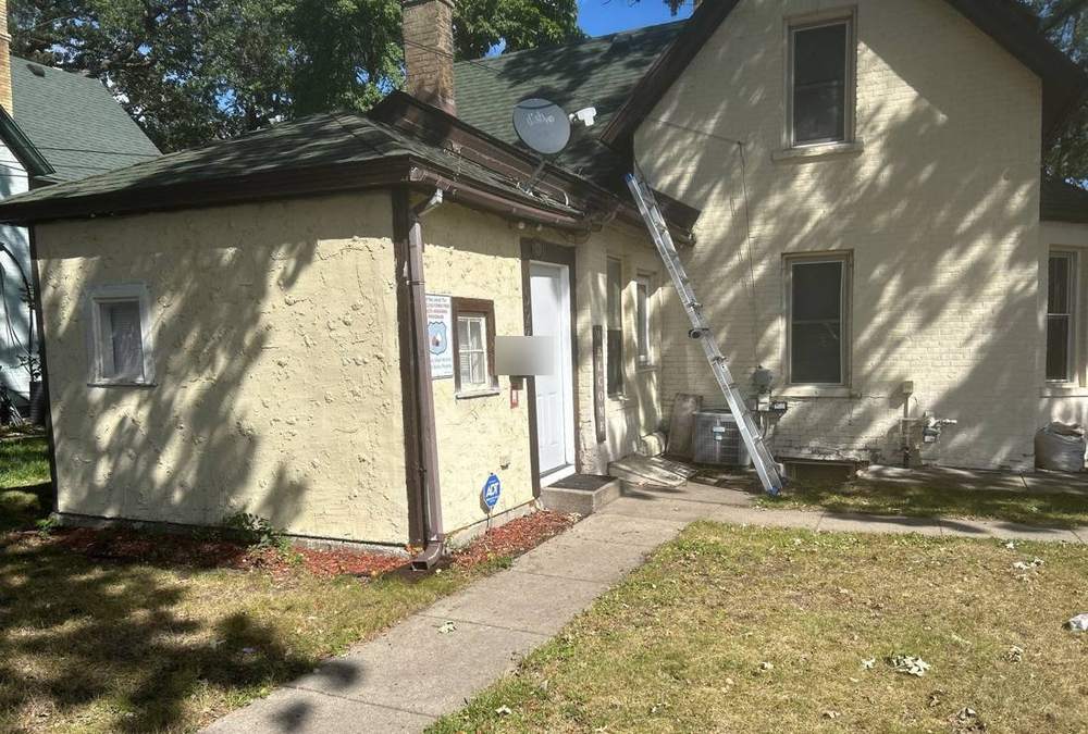 Older stucco two-story home in St. Cloud photographed during a roof inspection, September 2025