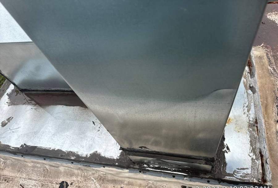 Split flashing at the base of a rooftop duct on the old Bloomington Lincoln dealership roof in Bloomington, MN, July 2024