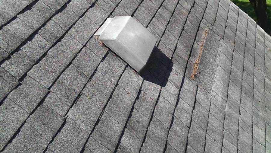 Close-up of worn, weathered asphalt shingles and a box vent on the Hinckley home before the tear-off