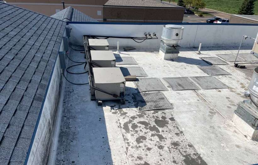 The flat roof deck and rooftop units behind the Culver's shingle roof, Waite Park
