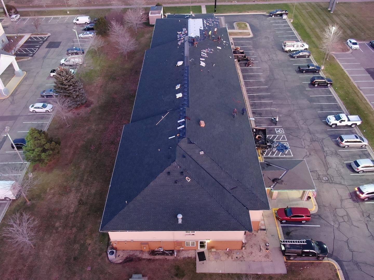 Aerial drone photo of a Repair King crew re-roofing a hotel with the property open and parking lot in use
