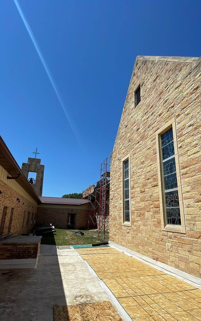 Stone bell tower and steep gabled roof of St. Paul Lutheran Church in St. James, MN, photographed by Repair King during a 2023 roof replacement