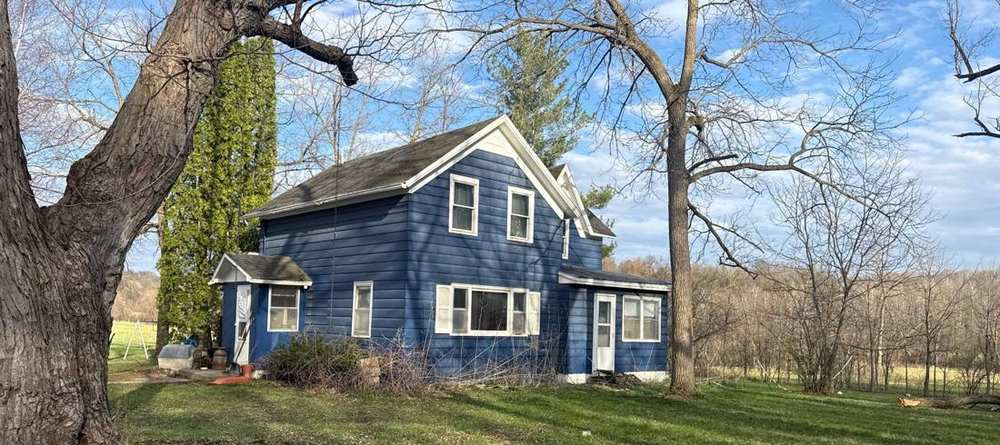Two-story farmhouse on a Rice County township property near Faribault, photographed during a roof inspection, April 2026