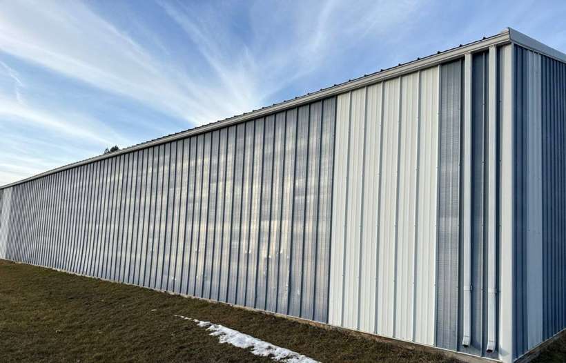 Long steel-sided farm building on a farmstead near Little Falls, MN, photographed by Repair King in January 2024