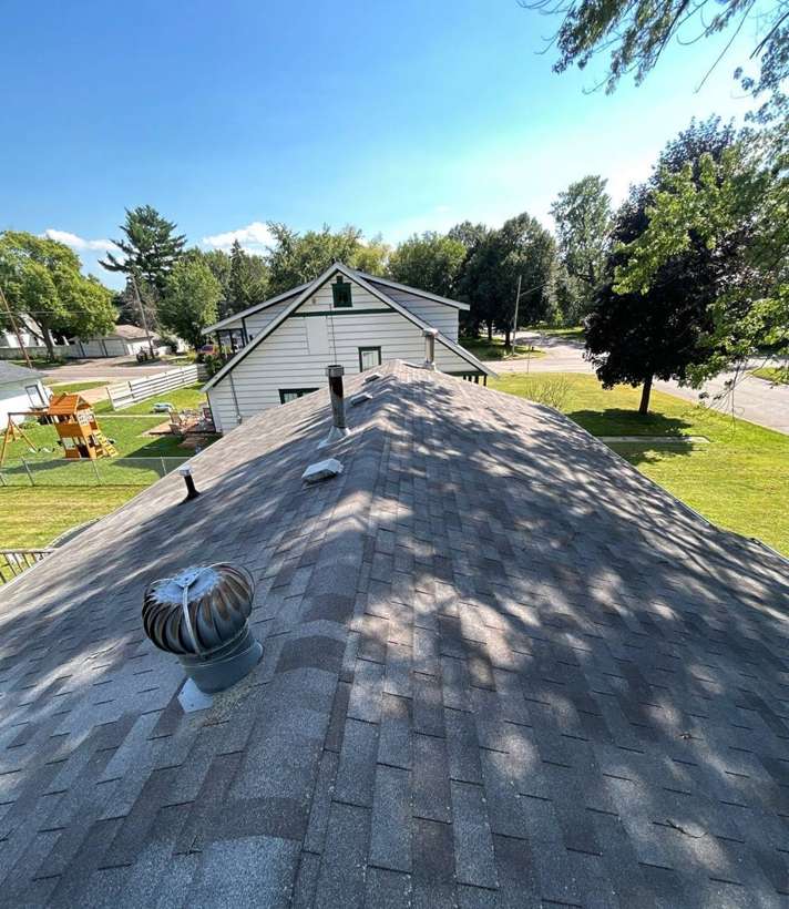 View along the shingle roof ridge and turbine vent of a St. Paul Park, MN home toward the neighborhood, during Repair King's September 2025 inspection