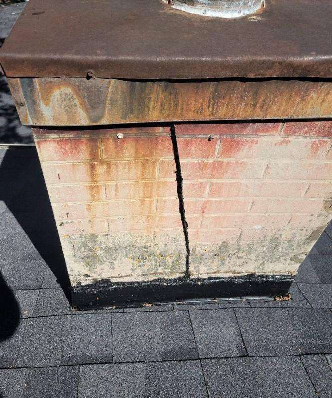 Cracked mortar joint and rusted metal cap on a chimney, Avon, August 2022