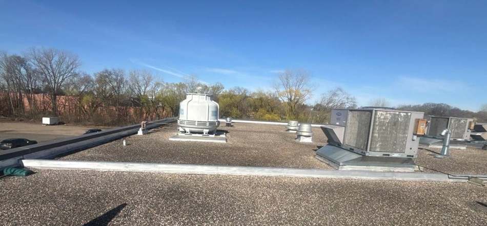 Rooftop HVAC units on the low-slope roof at Safe Reflections in Stillwater, April 2026