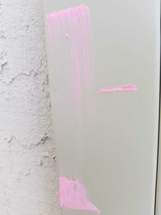 Pink chalk marking dents on aluminum window cladding next to stucco on a Prior Lake home, May 2018