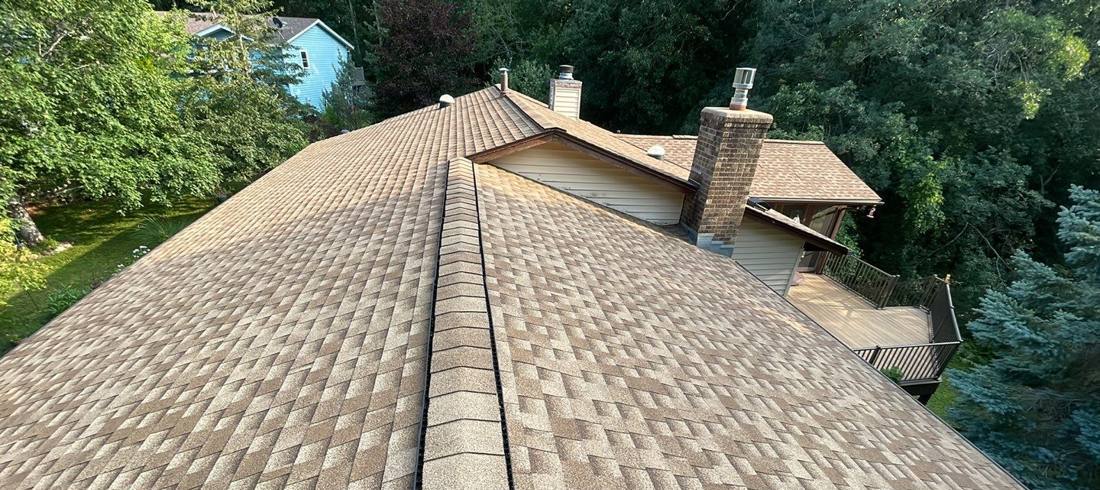 Ridge line and chimney flashing on a Lakeville roof during an inspection, July 2023