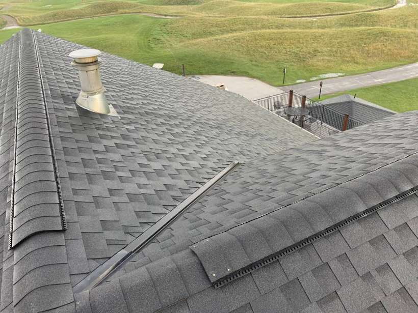 New shingles and a roof vent on the Coyote Moon Grille clubhouse, with the golf course behind, St. Cloud