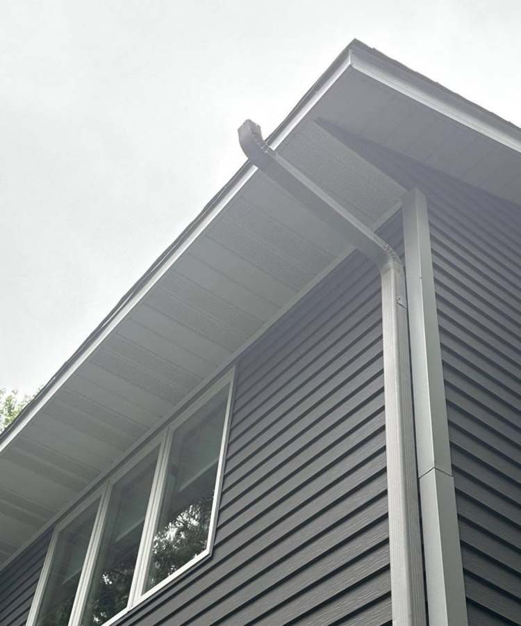 New charcoal lap siding, white soffit and downspout on a Lakeville home, June 2024