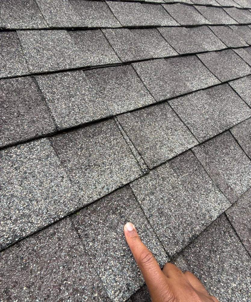 Hail hit pointed out on a Waconia shingle during a roof inspection, June 2025